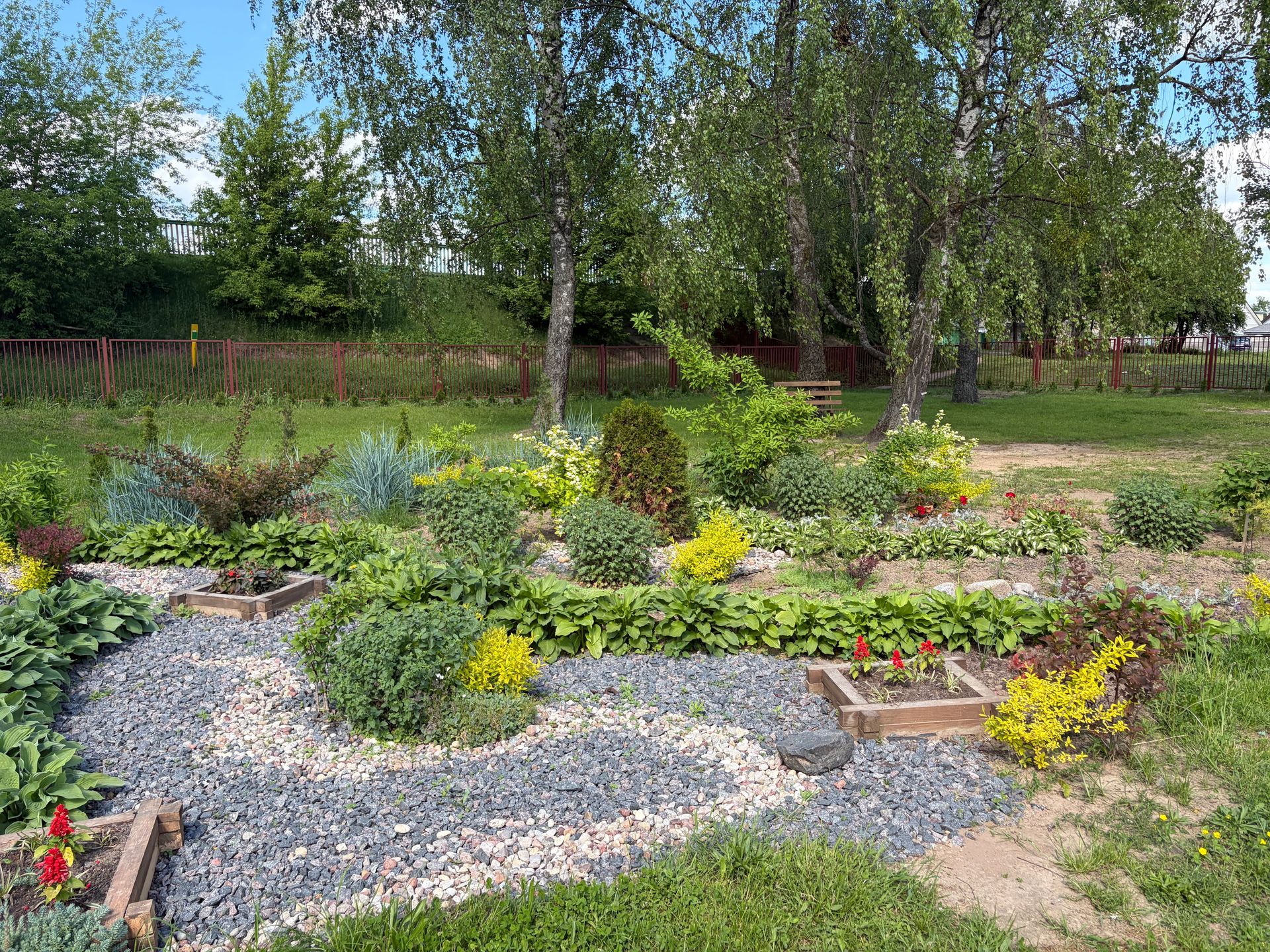 A beautiful spring garden featuring diverse plants and colorful flowers, perfect for relaxation and nature enthusiasts.
